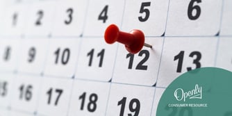 A red push pin is tacked to the number 12 on a calendar. 