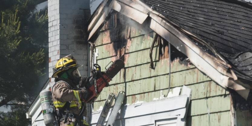 A fireman puts out a house fire. 