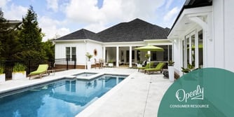 A rectangular swimming pool in the backyard of a one-story house. 