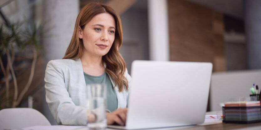 A woman types on a laptop.