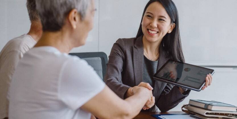 A woman shakes hands with a client. 